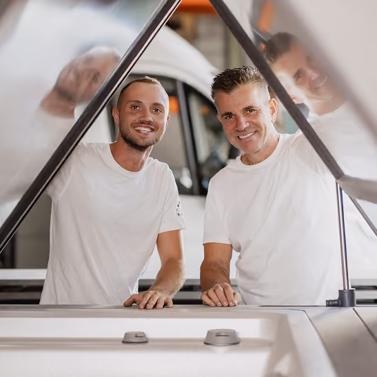 Roland Reinhart und ein Mitarbeiter stehen gemeinsam an einem Whirlpool.