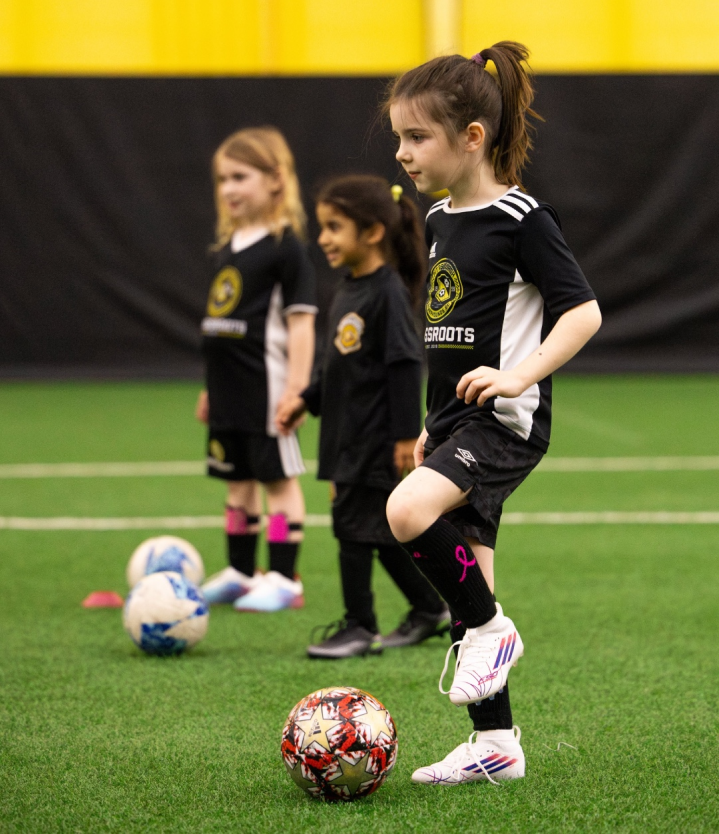 Young children playing in the grassroots soccer program