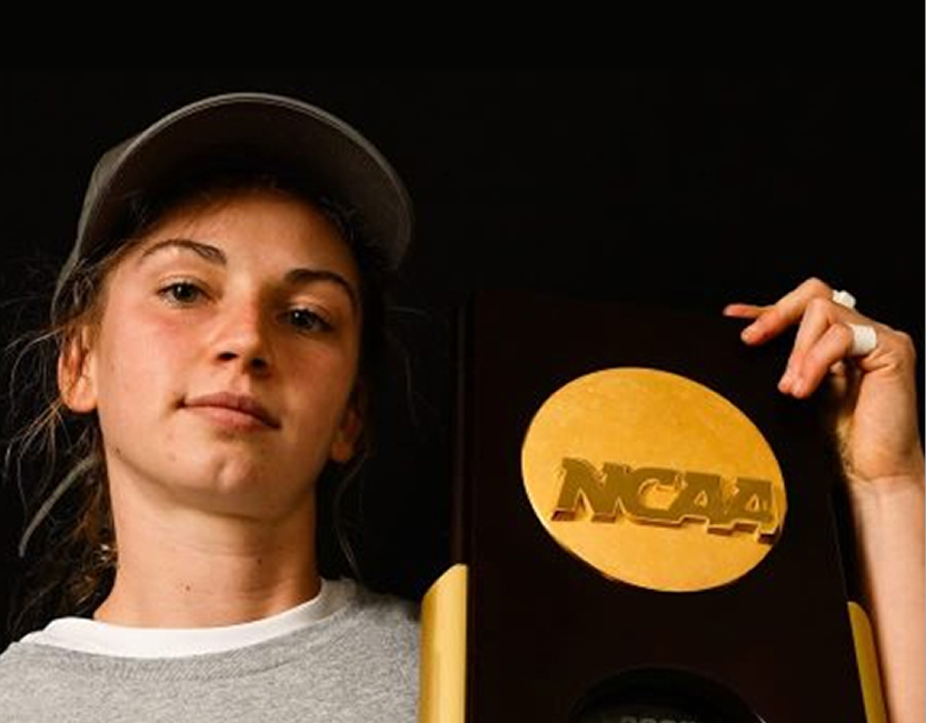 Academy graduate holding an NCAA championship trophy