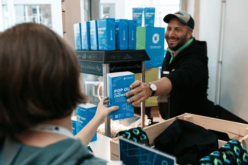 man handing a bag of popcorn to a woman