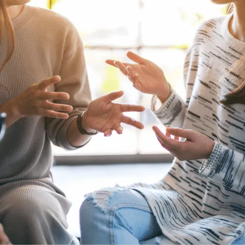 two people talking and sitting in front of each other
