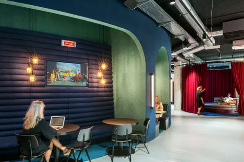 A picture of two smiling women in the audience raising their hands.