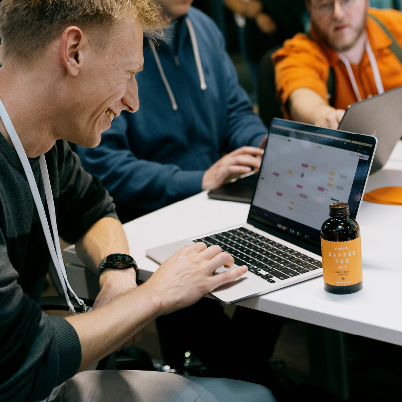 A picture of two smiling women in the audience raising their hands.