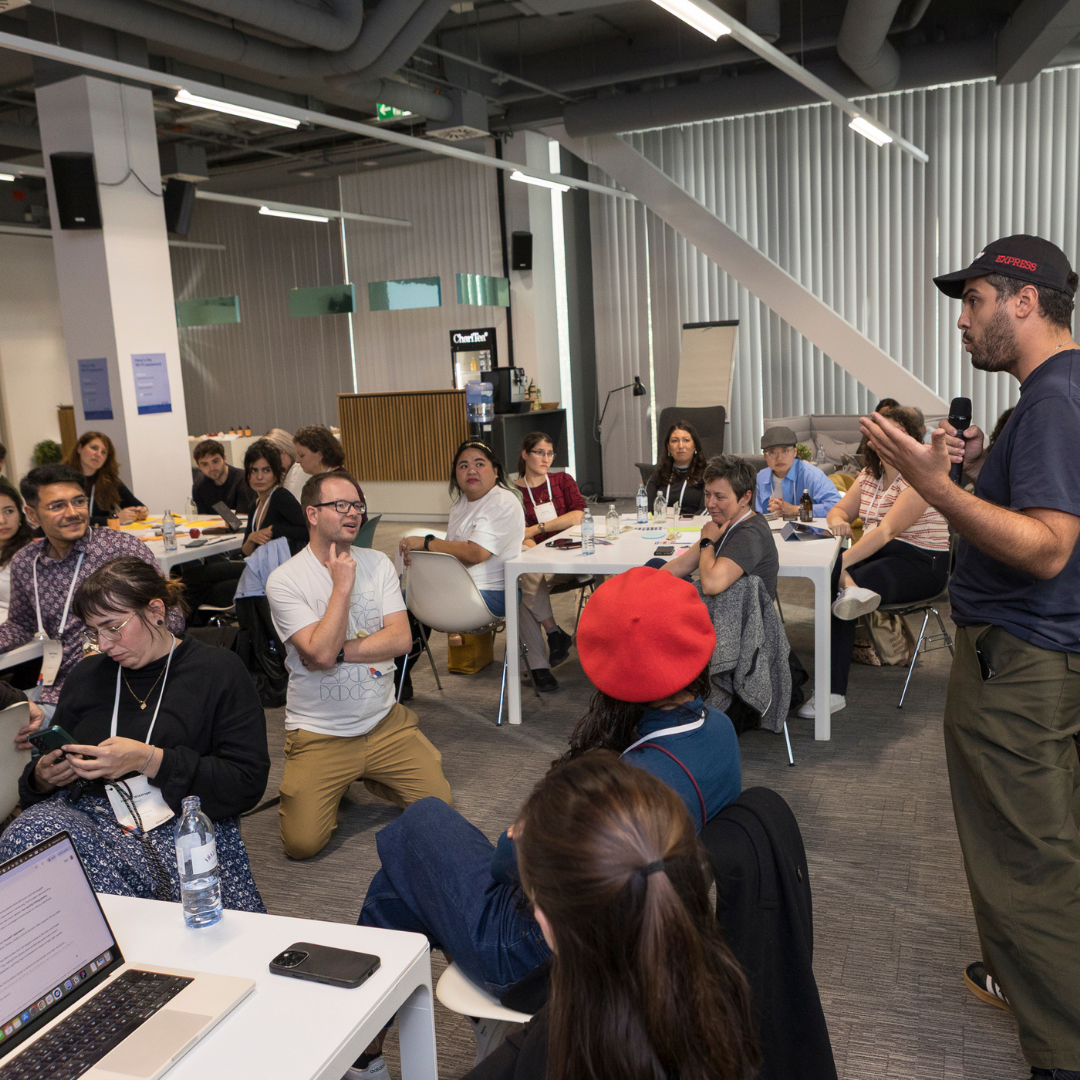 A picture of two smiling women in the audience raising their hands.