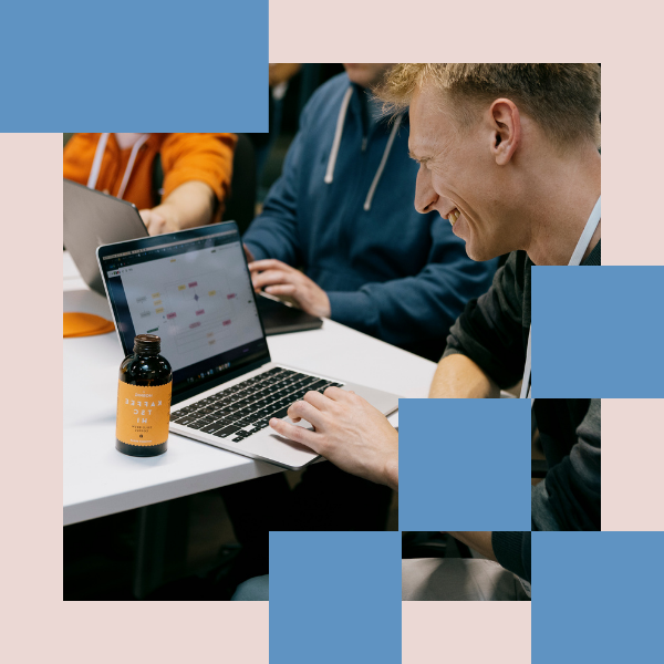 A person working on a laptop, smiling.
