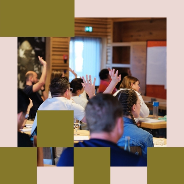 People in a workshop raising hands.