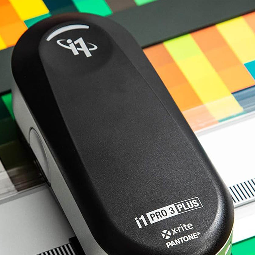 Espectrofotômetro X-Rite realizando medição de cor Pantone em folha de prova na Gráfica Exacta.
