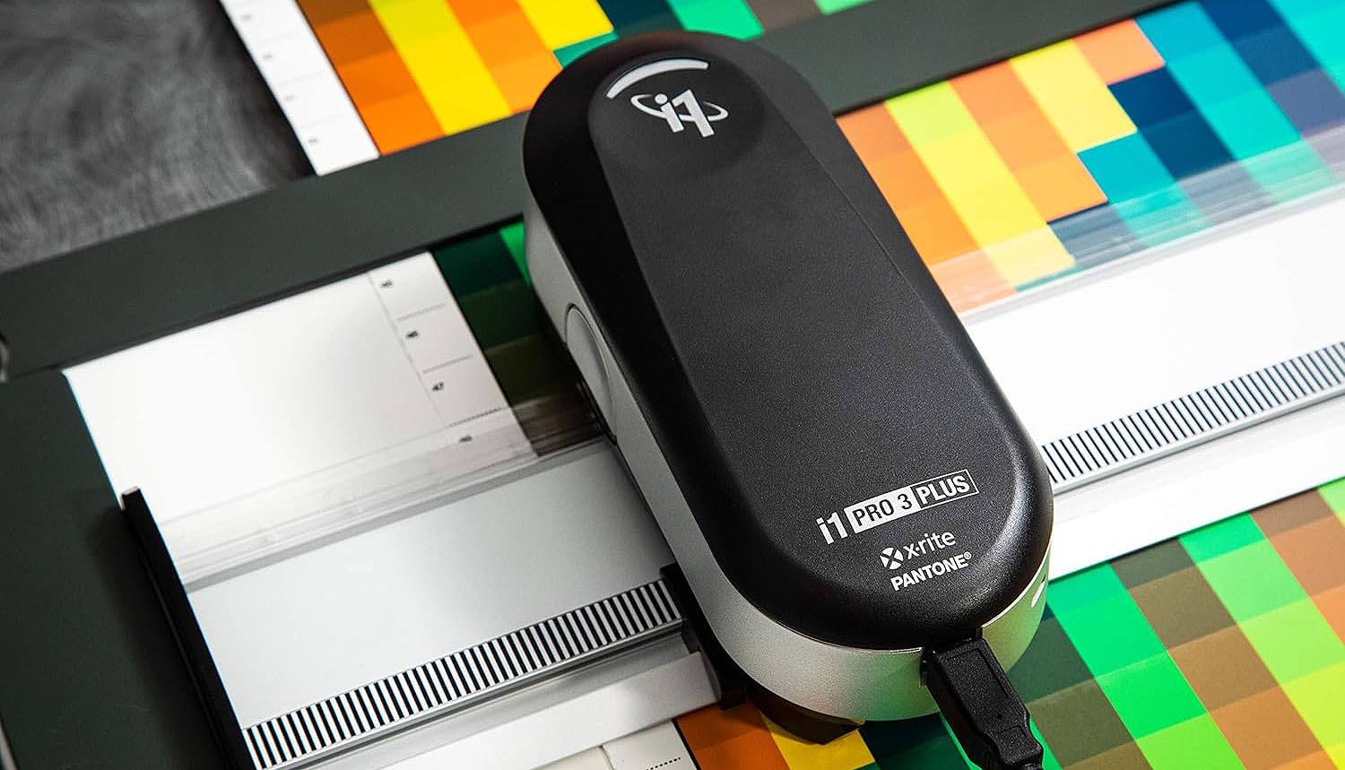 Espectrofotômetro realizando a leitura técnica de densitometria e gerenciamento de cores em folha de prova da Gráfica Exacta.