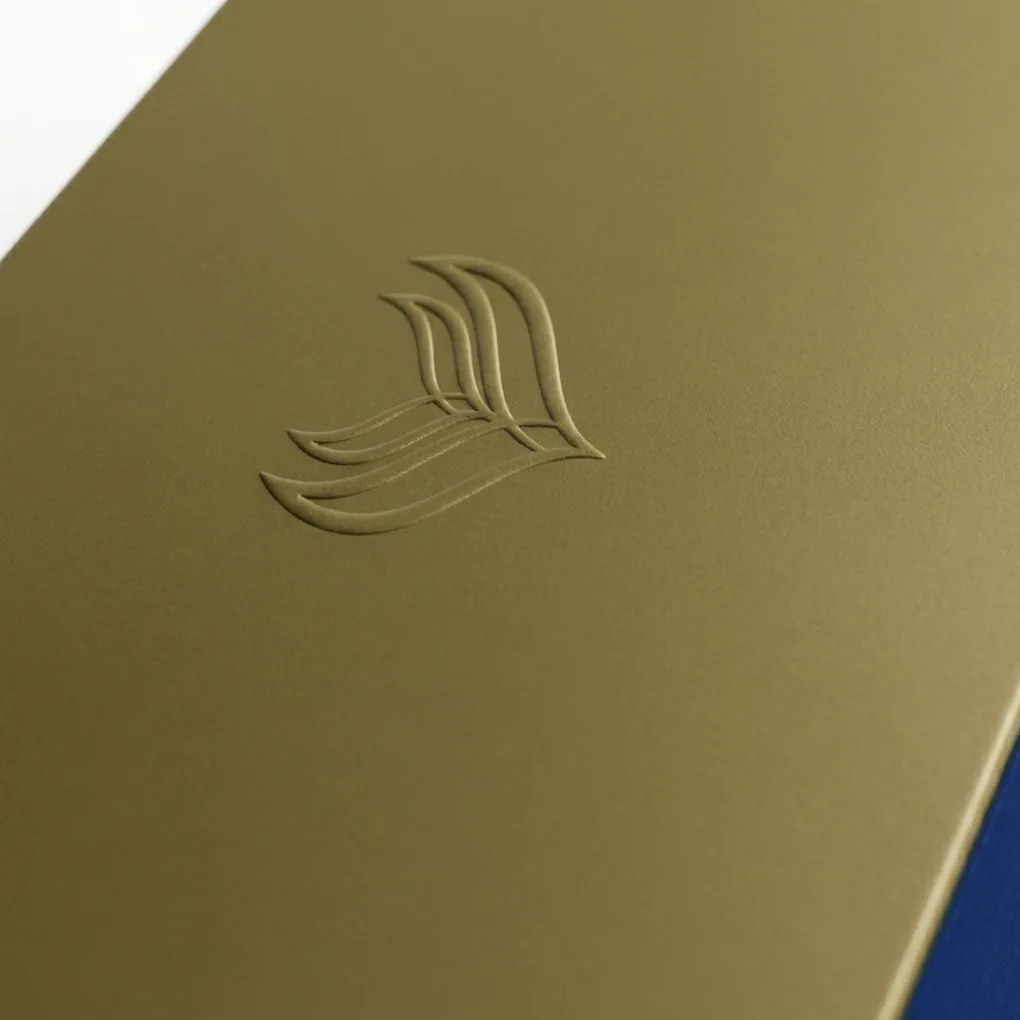 Qualidade superior impressão em pantone® com controle de cor, relevo seco e hotstamping. Detalhe relevo seco.