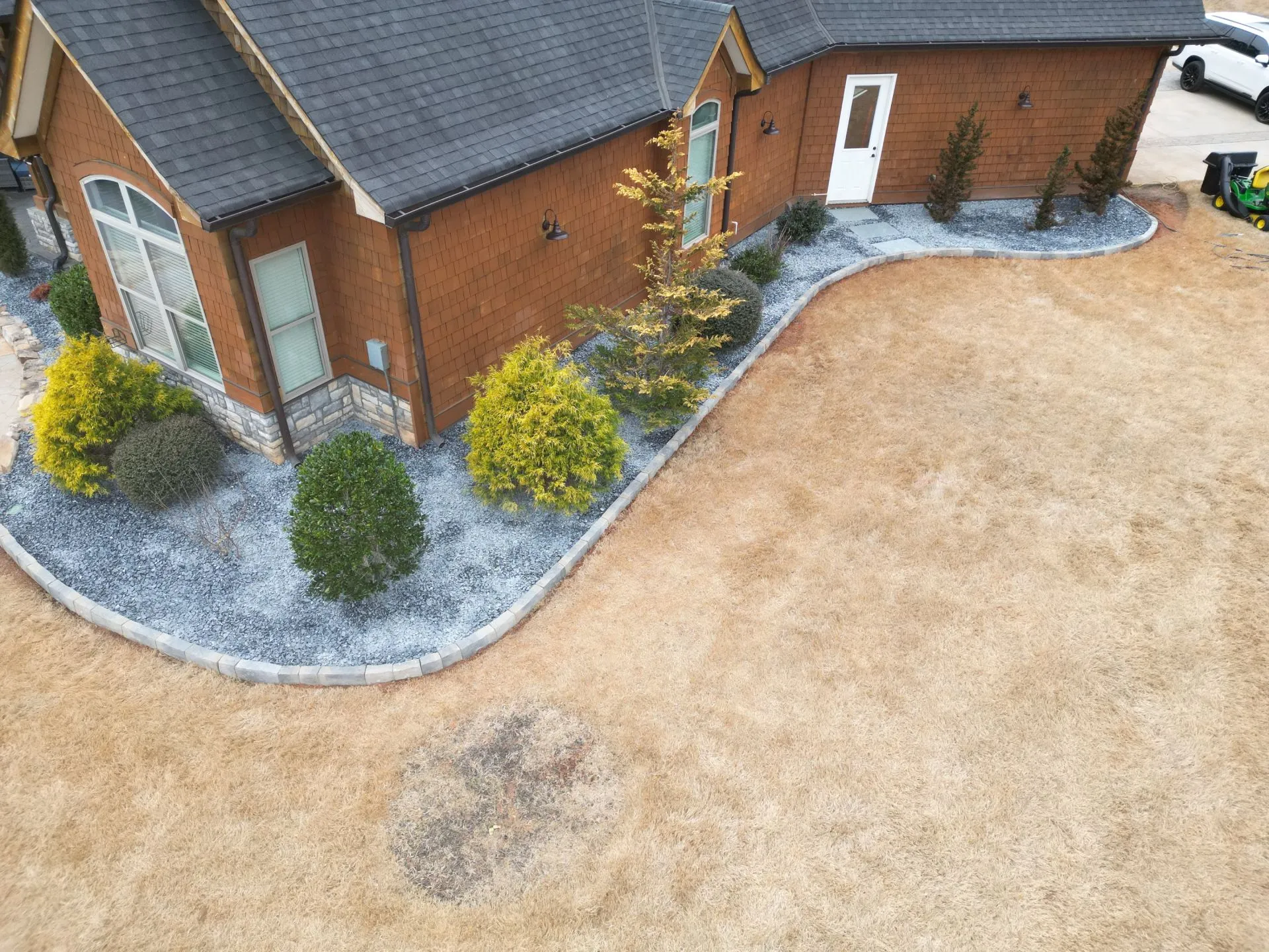 Foundation planting and rock bed installation along the home exterior