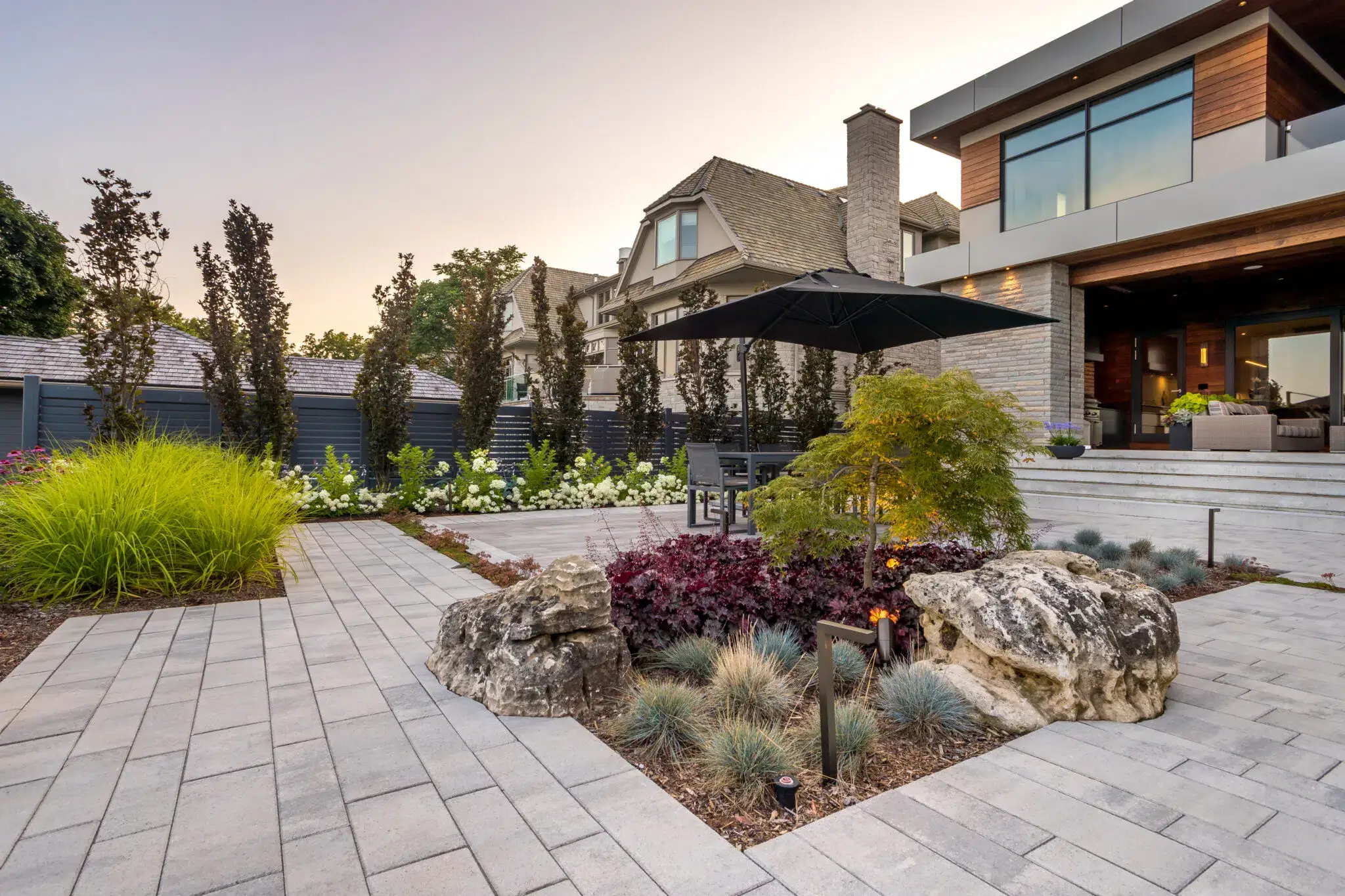 Patio landscape design with garden beds and stone accents