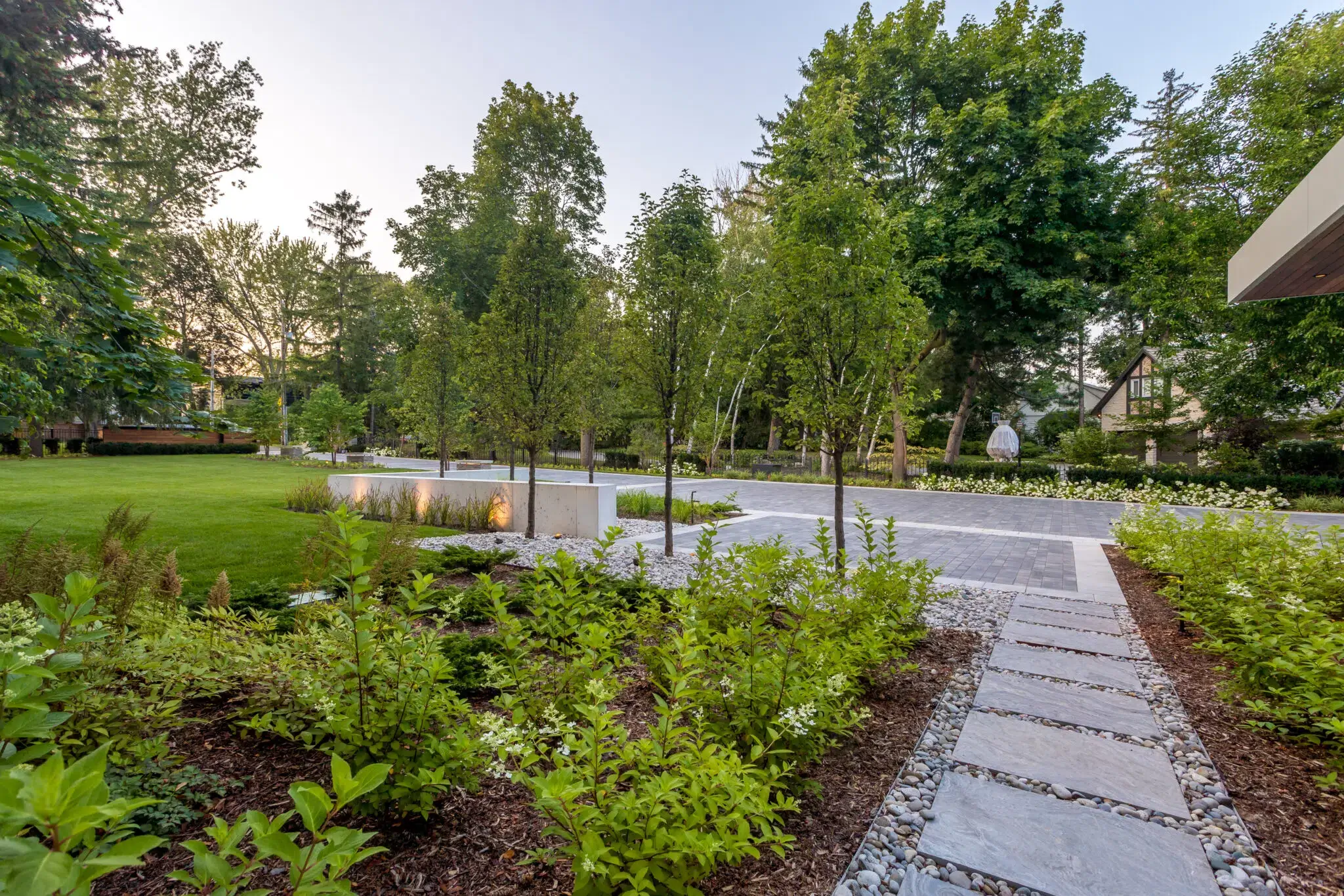 Front walkway landscaping with garden beds and mature trees