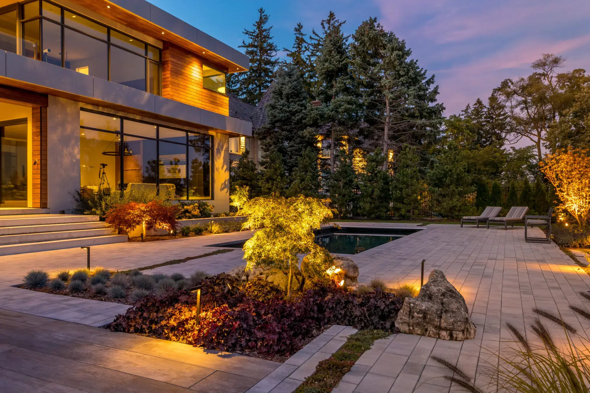 Landscape lighting highlighting garden beds and poolside walkway