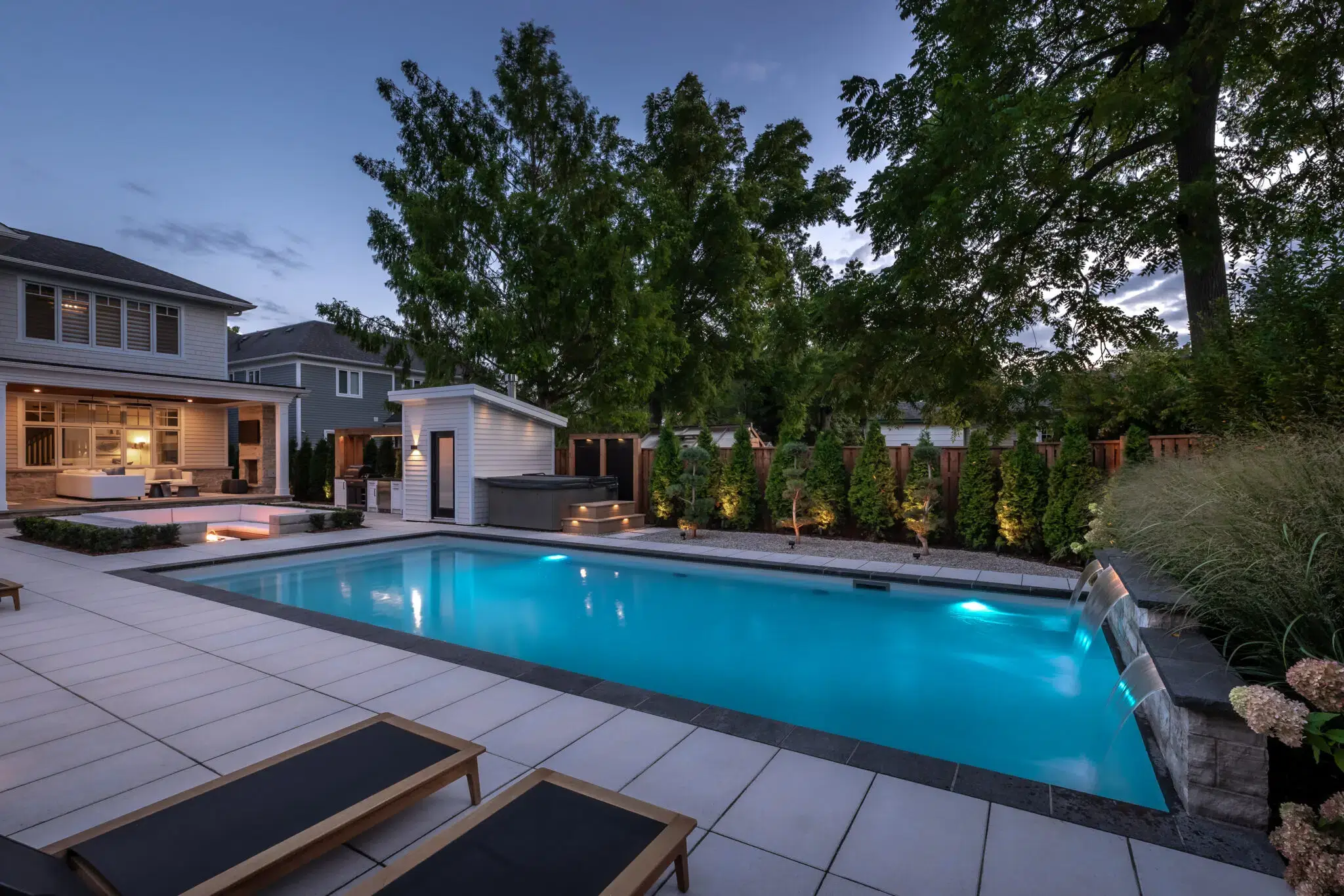 Landscape construction featuring a backyard pool, patio, and lighting