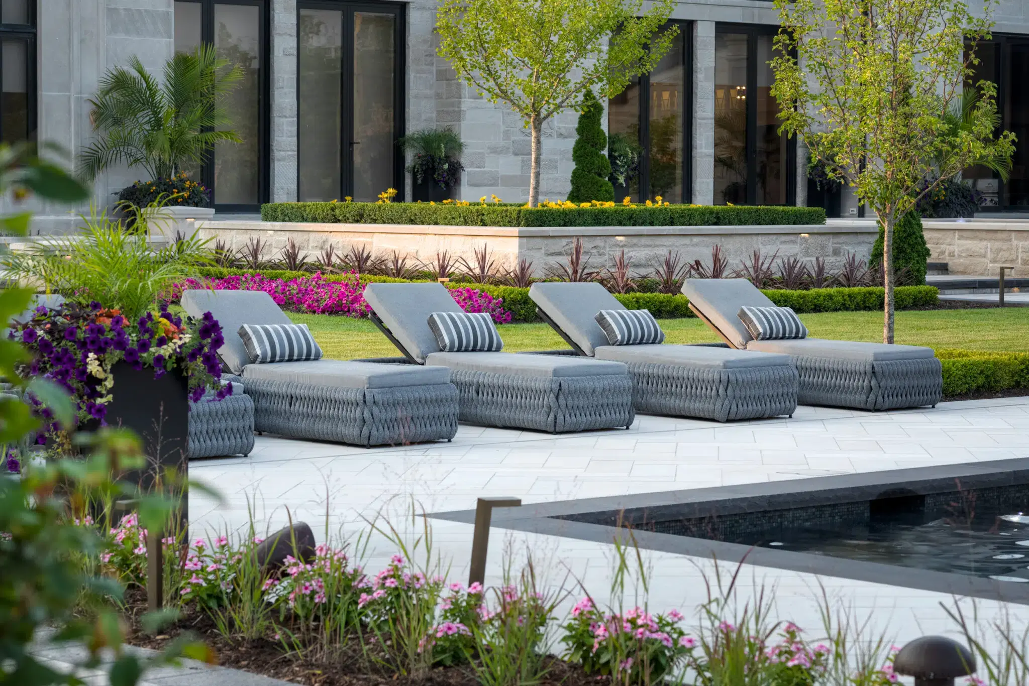Backyard landscape design with poolside patio and flower beds