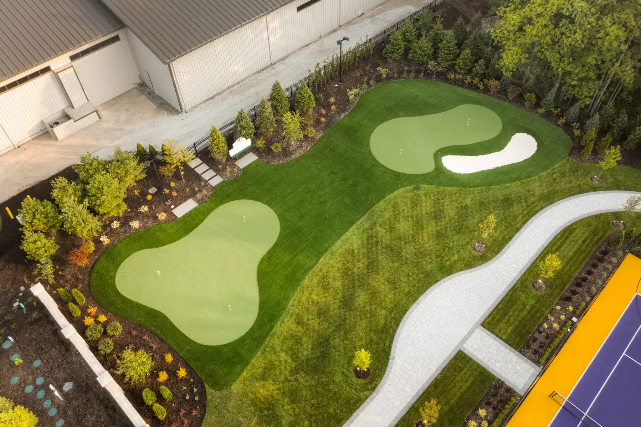Commercial landscape construction with putting greens and curved walkway