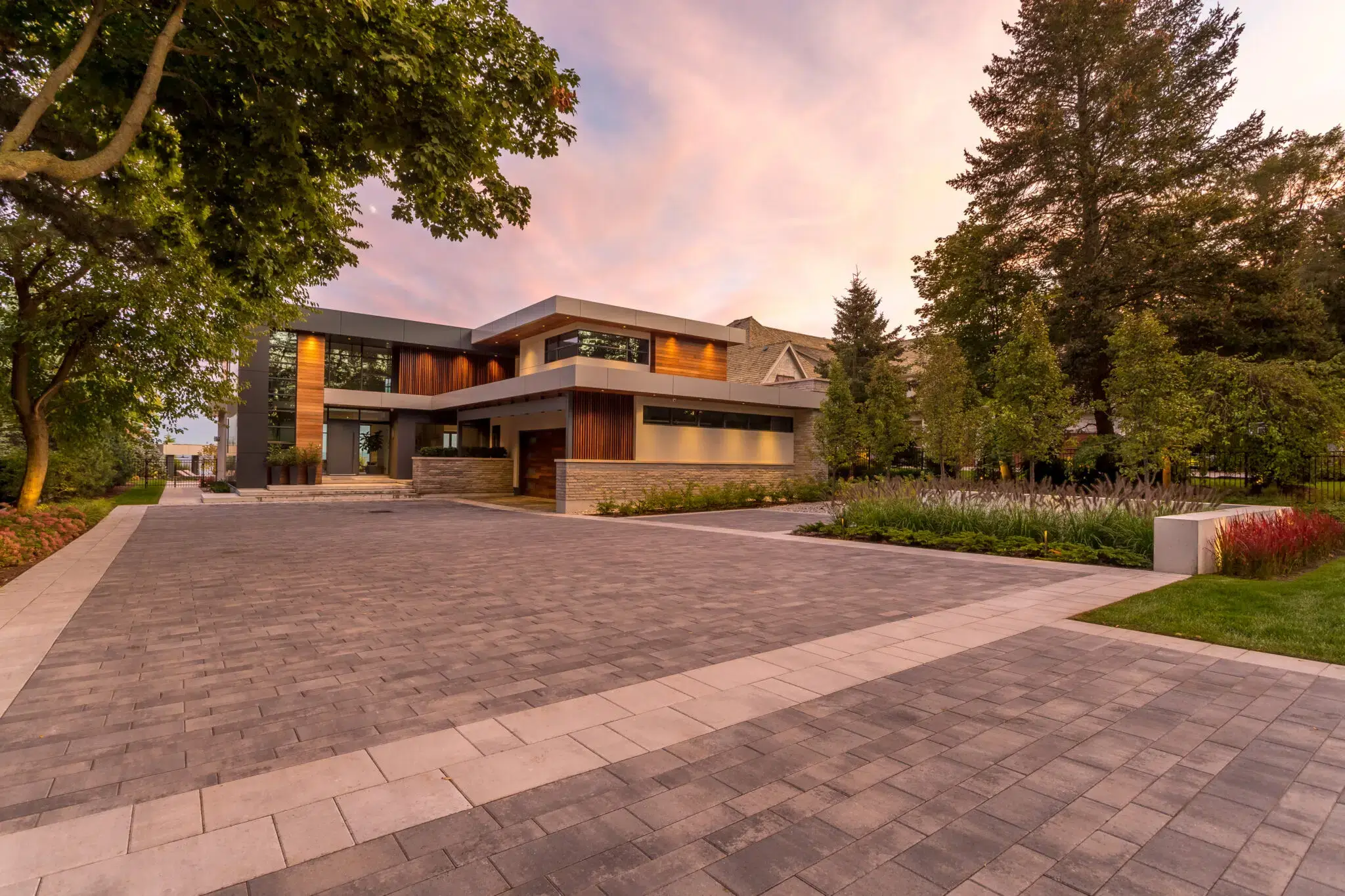 Front yard landscaping with paver driveway and garden beds