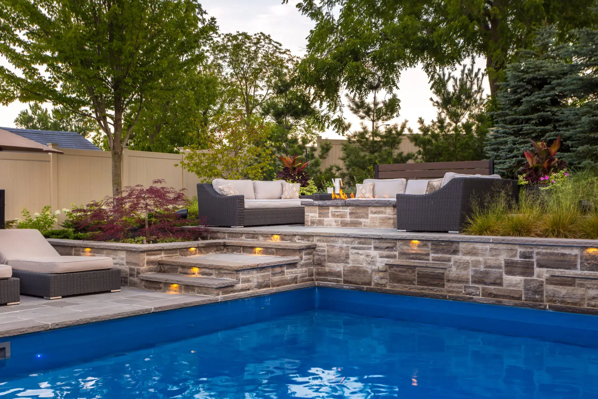 Poolside hardscaping with stone steps and landscaped seating area