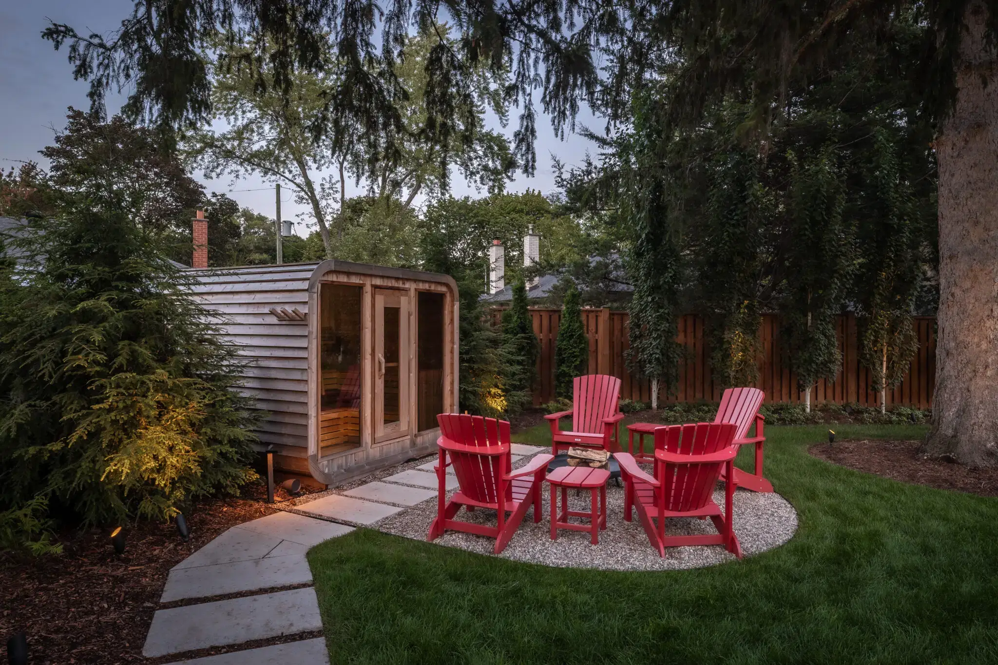 Backyard landscaping with sauna, seating area, and stone walkway