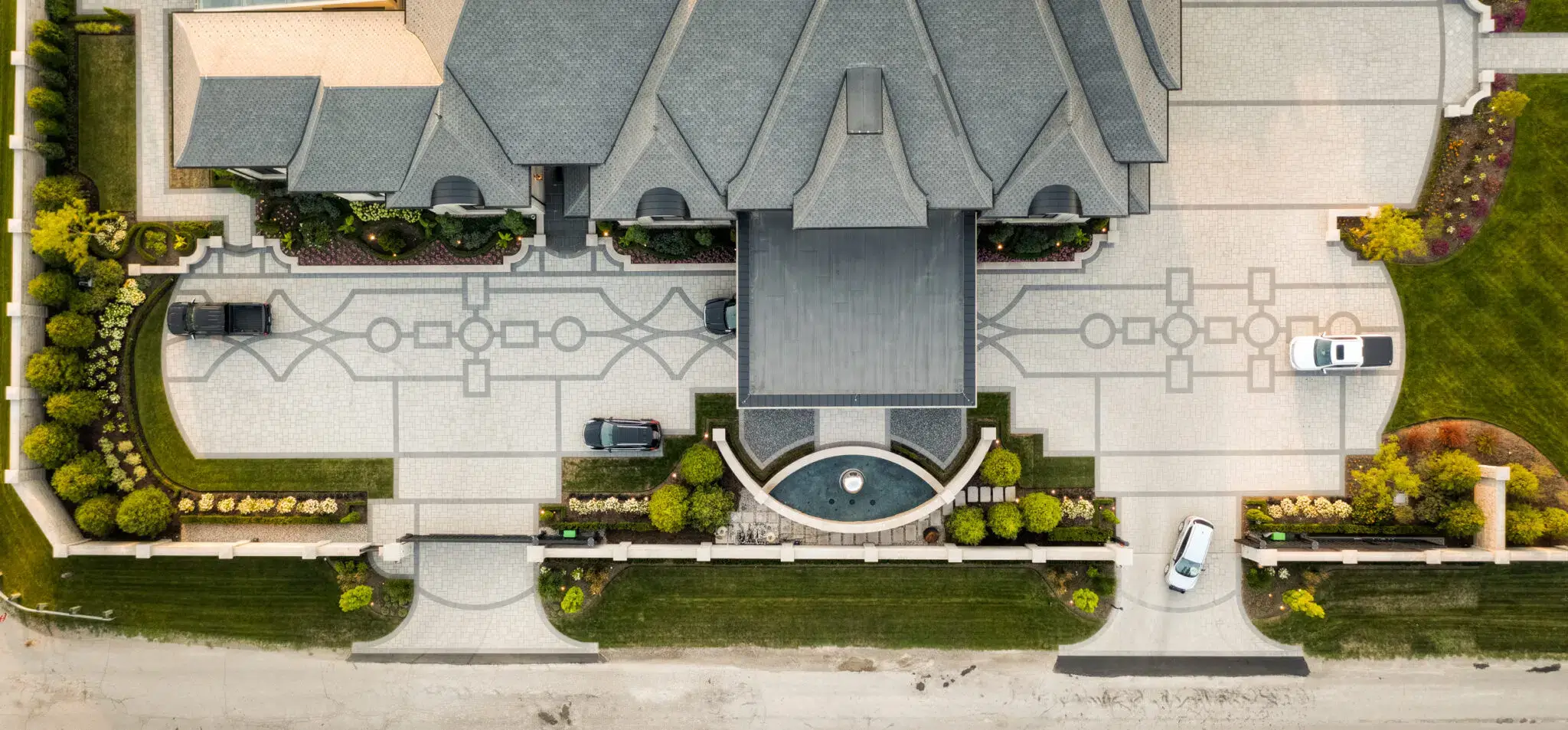 Custom Home Landscaping With Patterned Paver Driveway