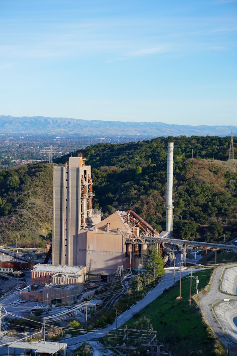 An industrial plant with mountains behind it, as Switzerland considers a carbon border charge on imported cement