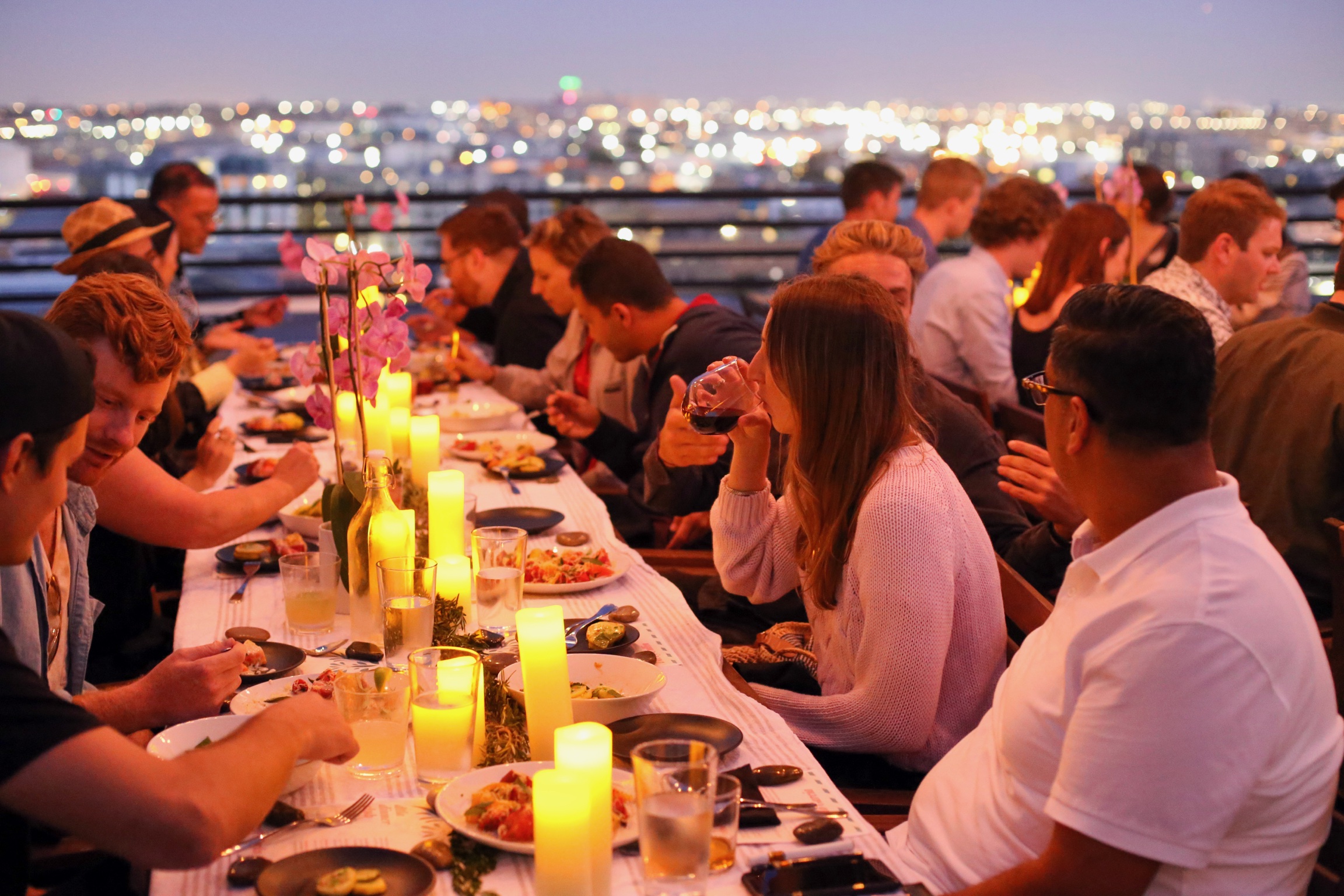 DTLA Dinner Club enjoying a rooftop dinner with a view of the LA skyline