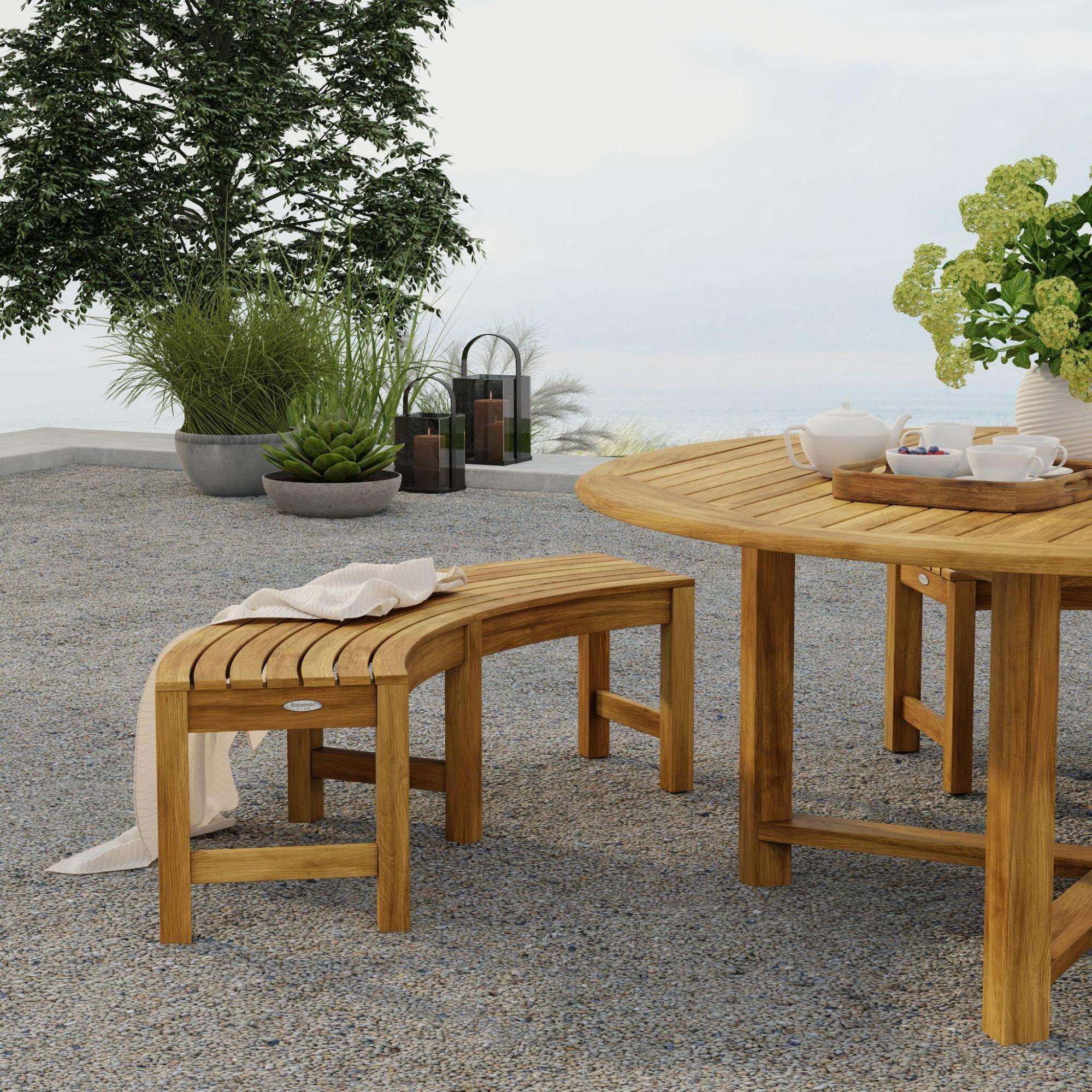 An image of 70090 Buckingham Picnic Dining Set with optional seat cushions on outdoor patio with flower vase and tray of coffee and cups with landscape plants and trees in background.