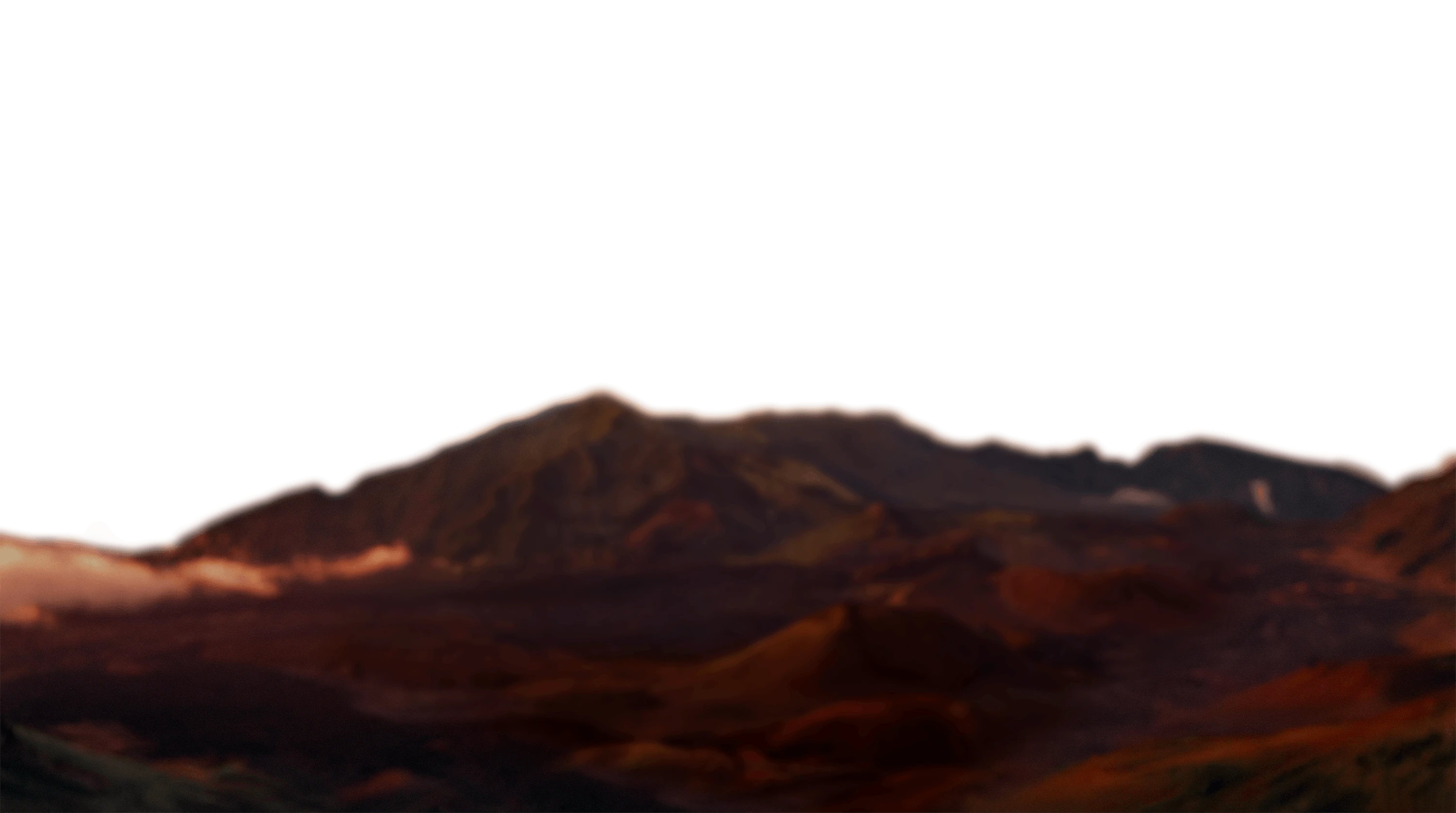 Distant mountain range with a warm sunset casting reddish and orange hues over the landscape.