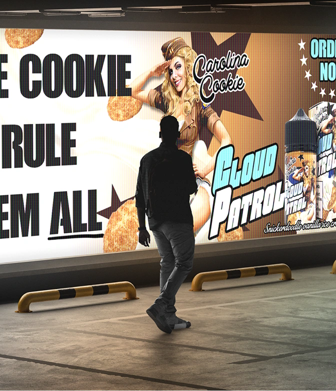 Person standing in front of a large illuminated advertisement for Carolina Cookie Cloud Patrol e-liquid featuring a smiling woman in a vintage outfit and cookies.