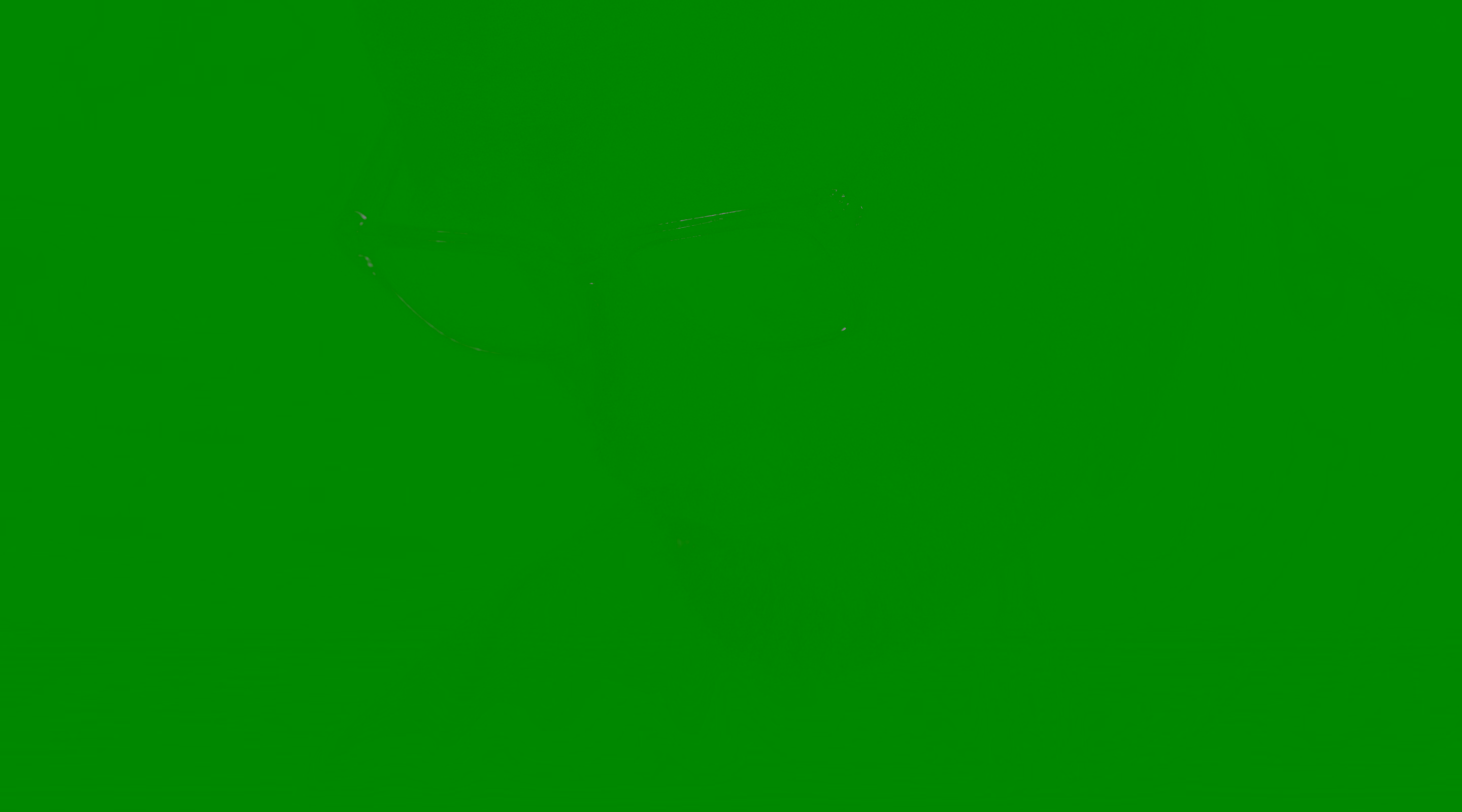 Close-up of a contemplative older man with a gray beard wearing translucent rectangular glasses in dim lighting.