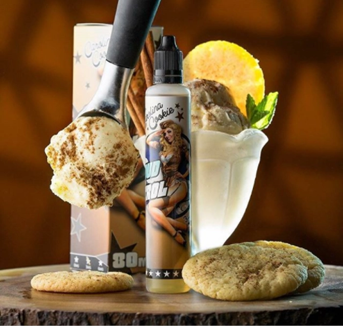 A scoop of cinnamon cookie ice cream above two cinnamon cookies, a dessert glass with ice cream garnished with mint and a cookie, and a bottle labeled Vanilla Cookie e-liquid.