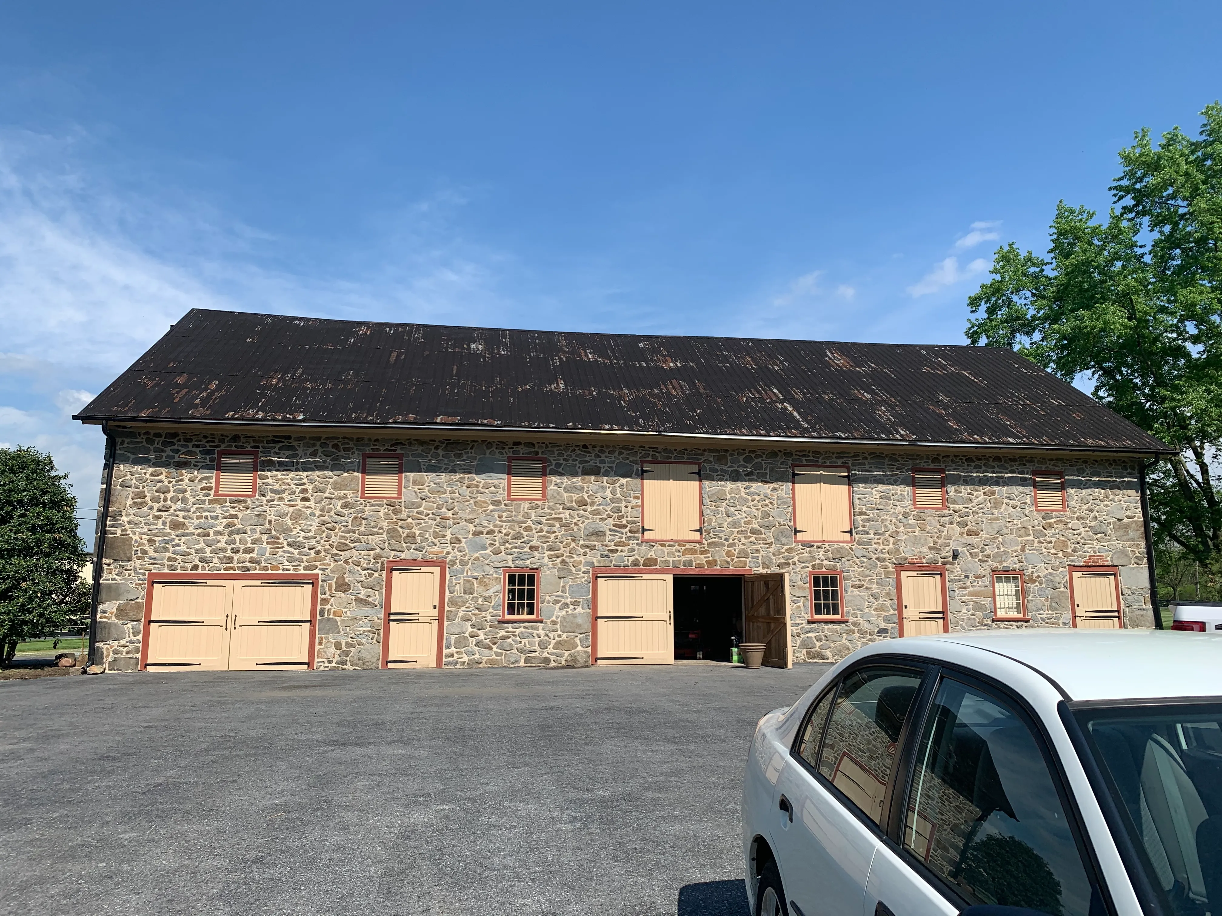 Moonstone Manor's original historic barn with a dilapidated roof and fieldstone walls.