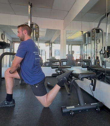 Physical therapist demonstrating hip mobility drill for HYROX athletes