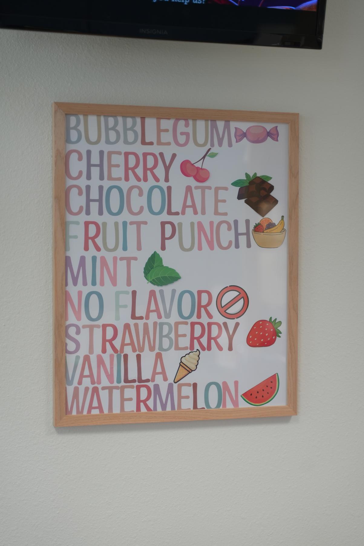 Framed poster listing toothpaste flavors like bubblegum, mint, and strawberry