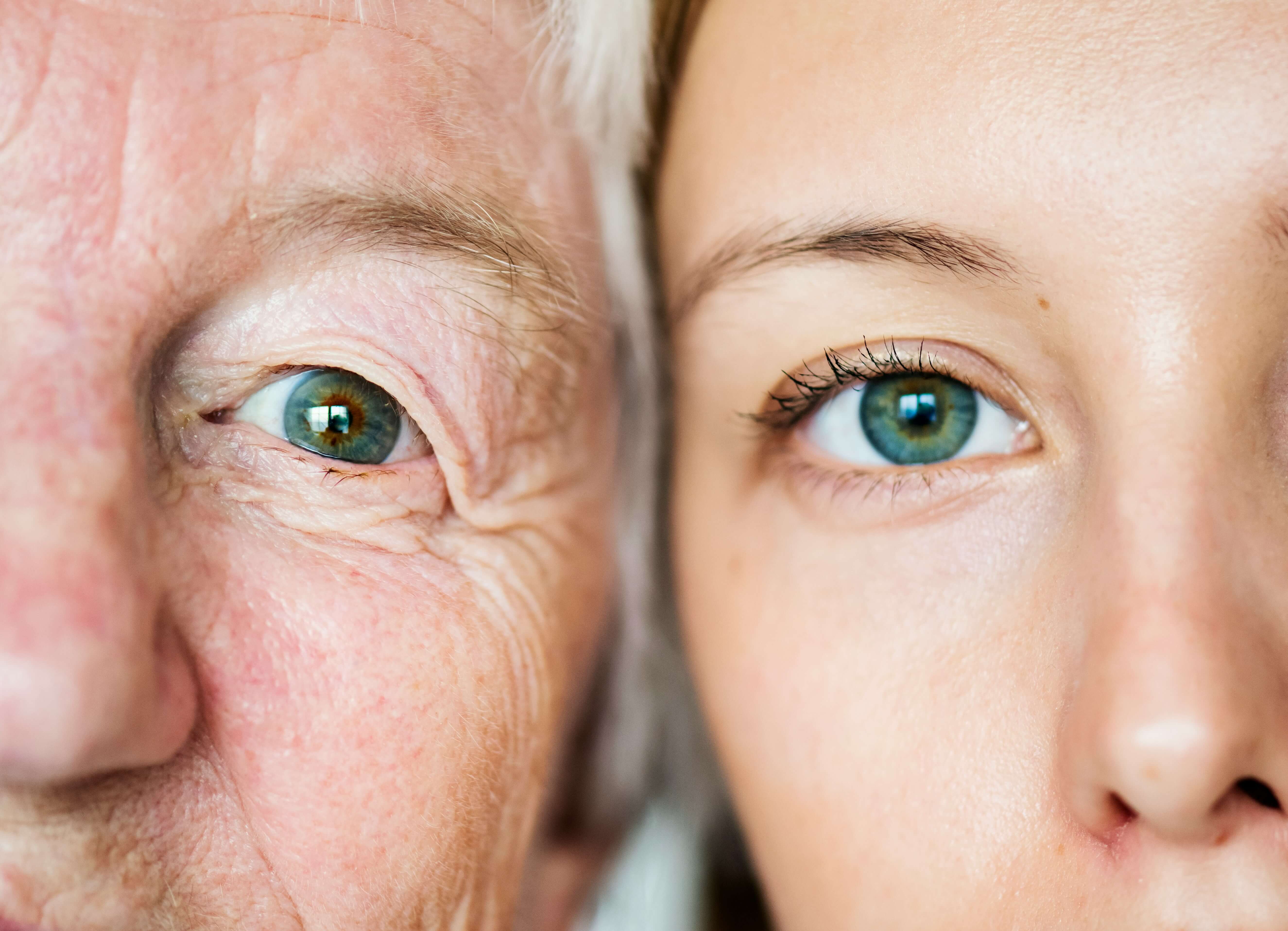 Close-up of the eyes and part of the faces of an elderly person and a young adult side by side, highlighting differences in skin texture and age.