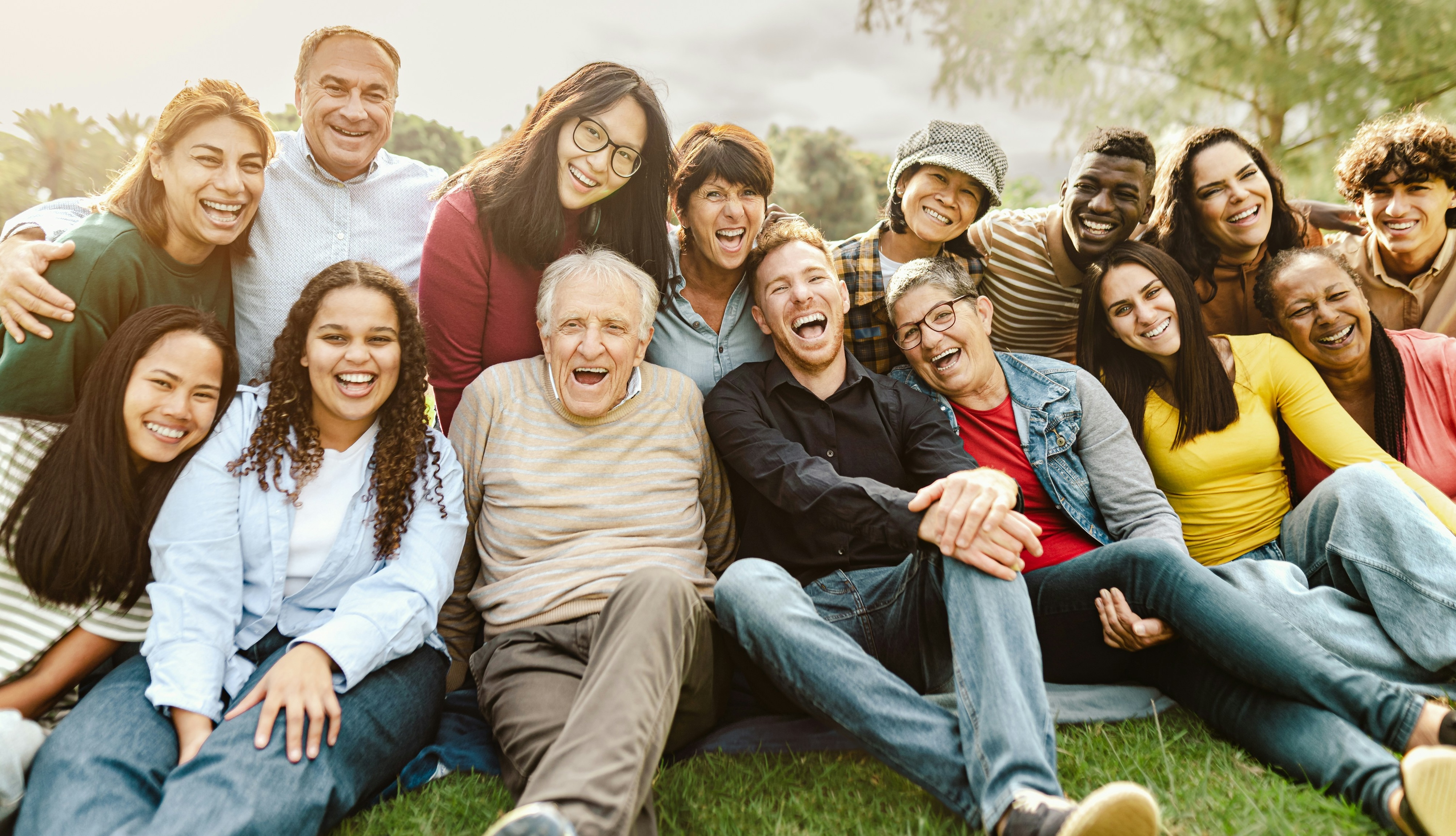 A big circle of family and friends laughing together outdoors