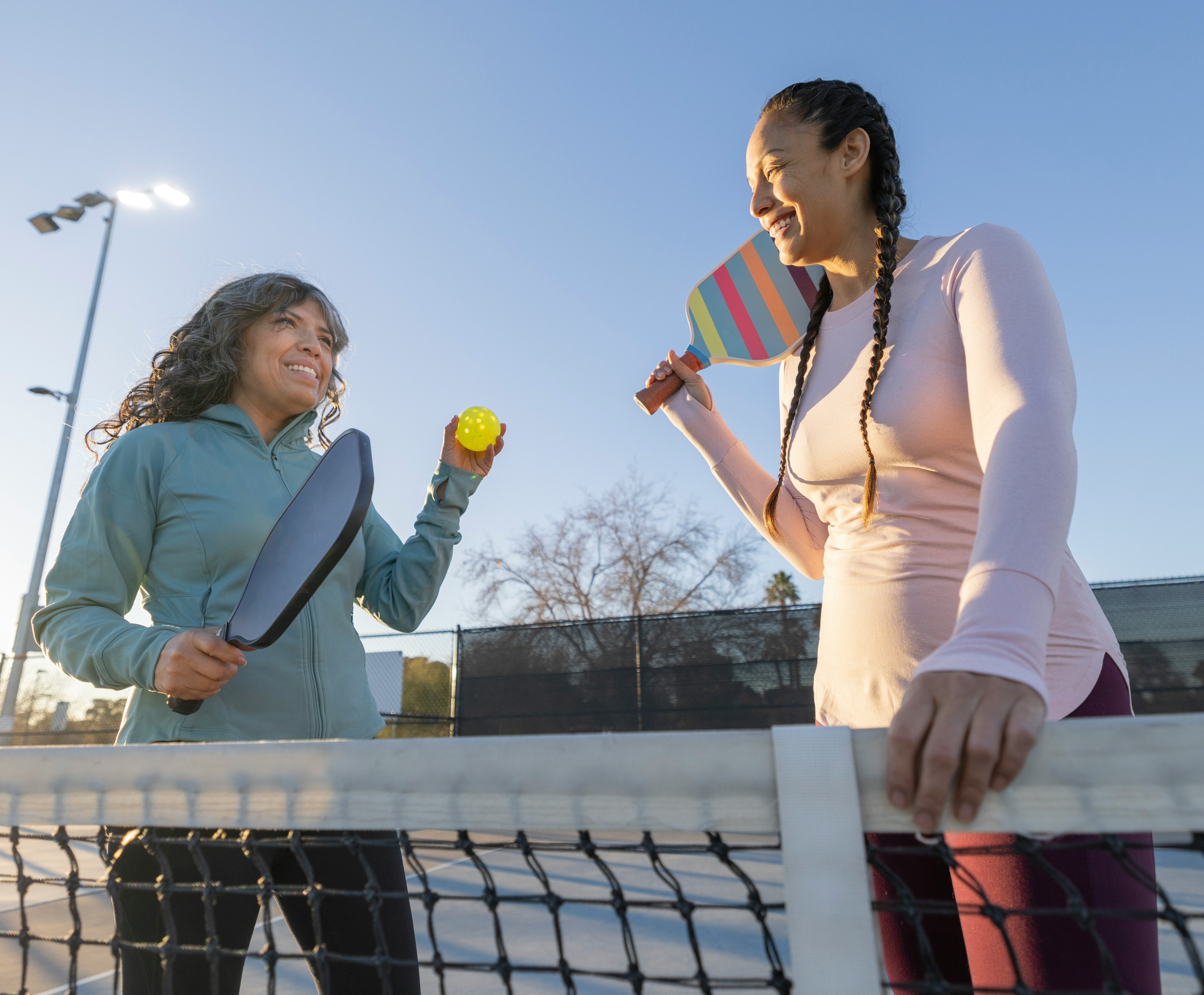 Two friends laughing over a game of pickleball