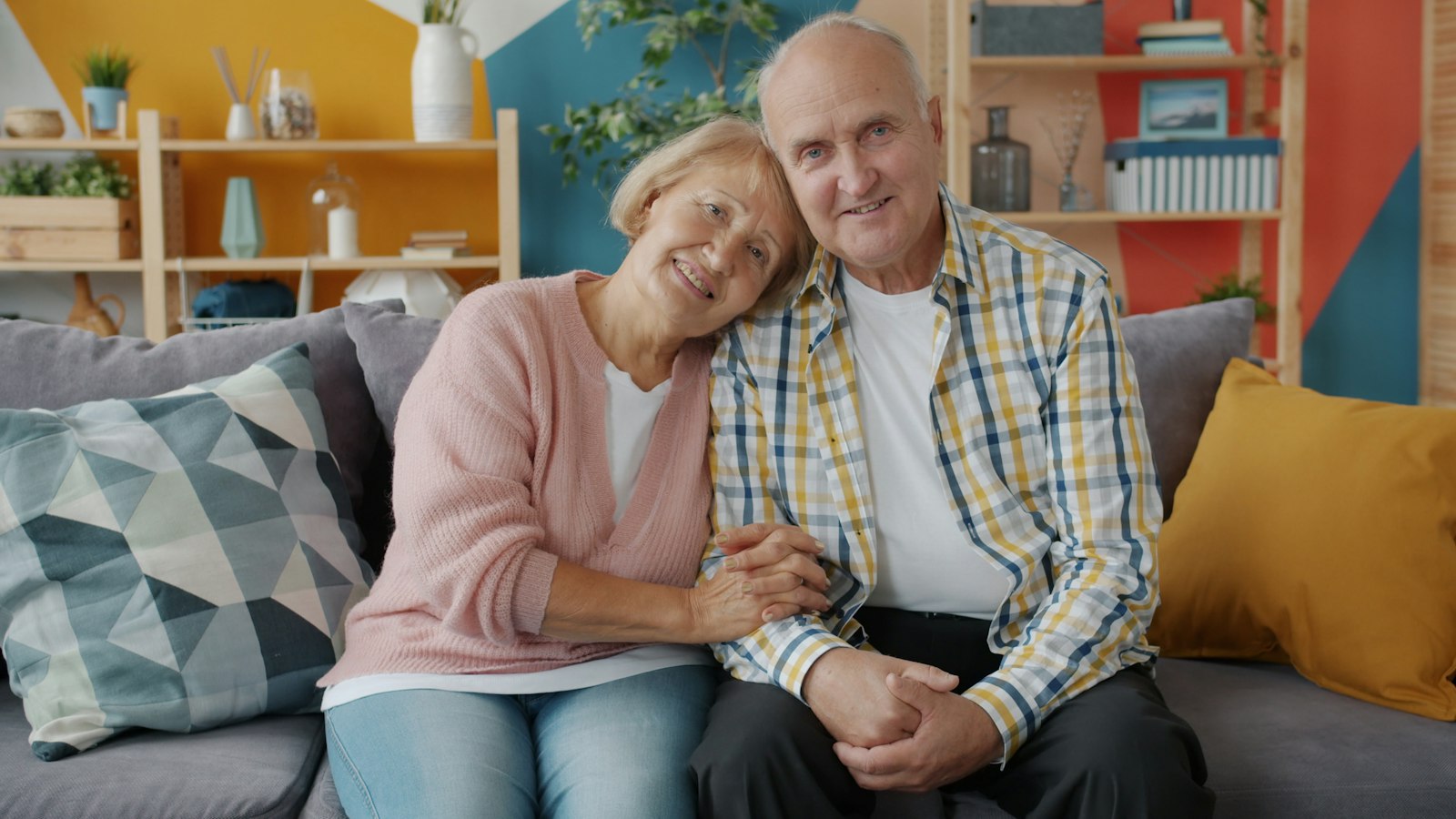 An older couple smiling together on the couch at home