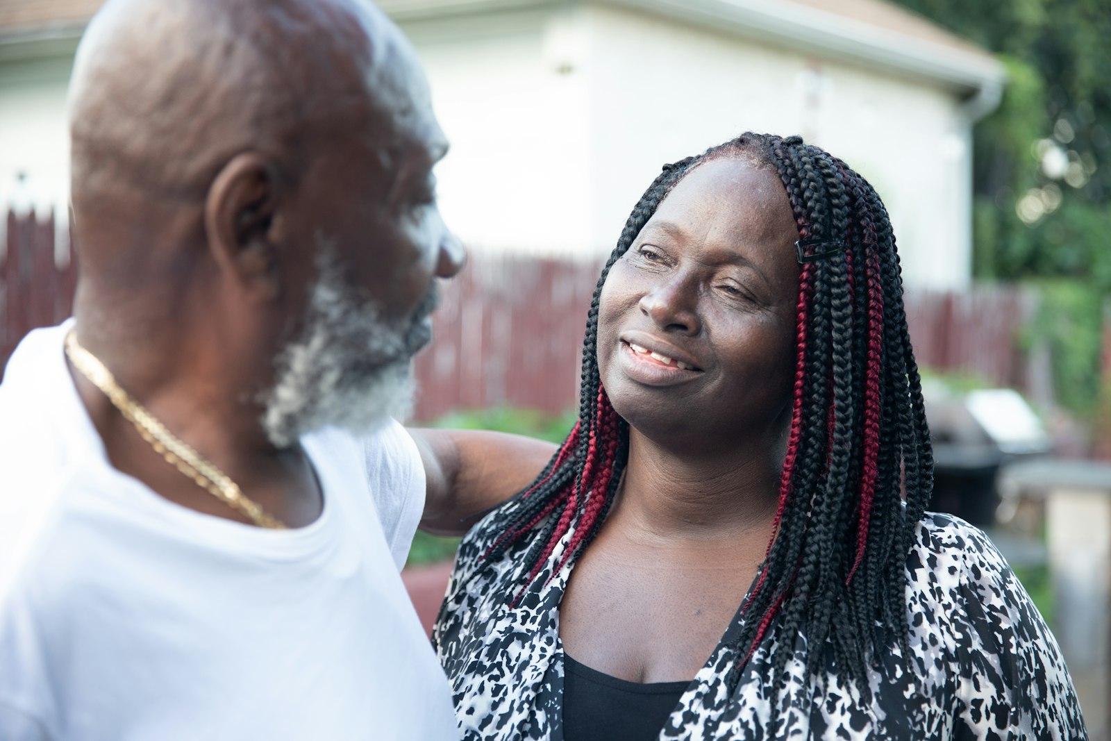 A smiling woman outdoors with her father on a sunny day