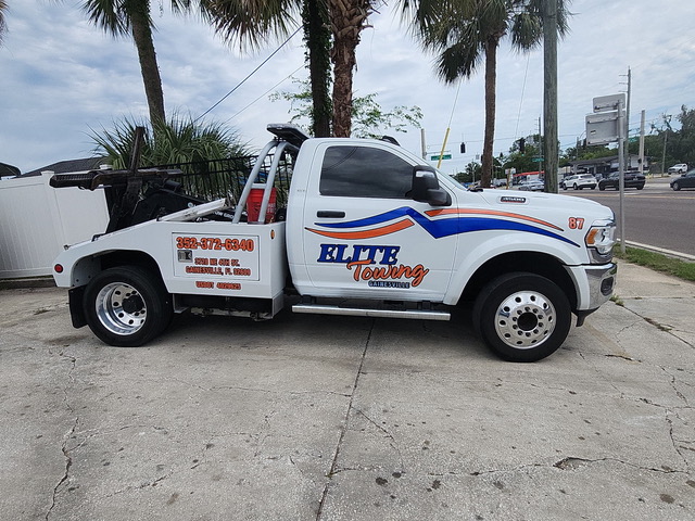 Elite Towing and Recovery flatbed tow truck loading a vehicle in Gainesville, FL