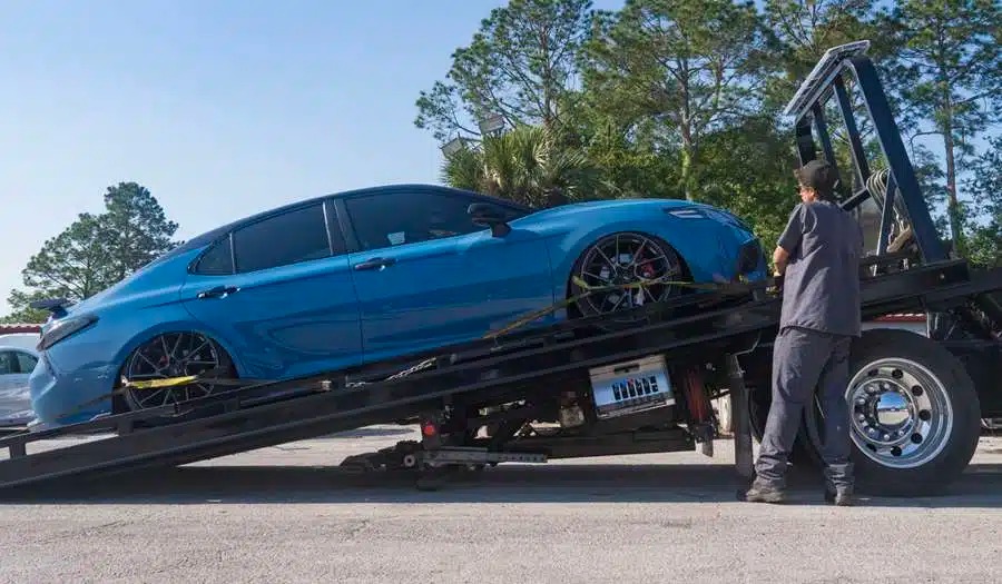 Elite Towing and Recovery flatbed truck transporting a recovered car in Gainesville, FL