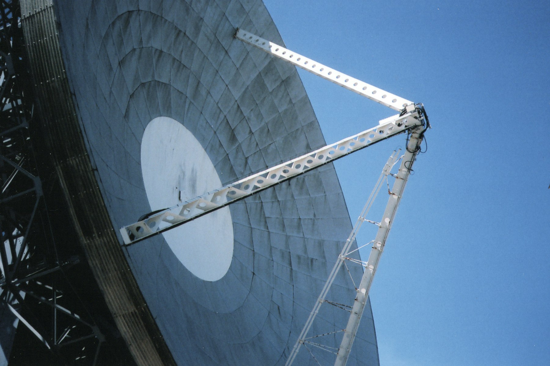Large satellite earth station dish against a clear blue sky