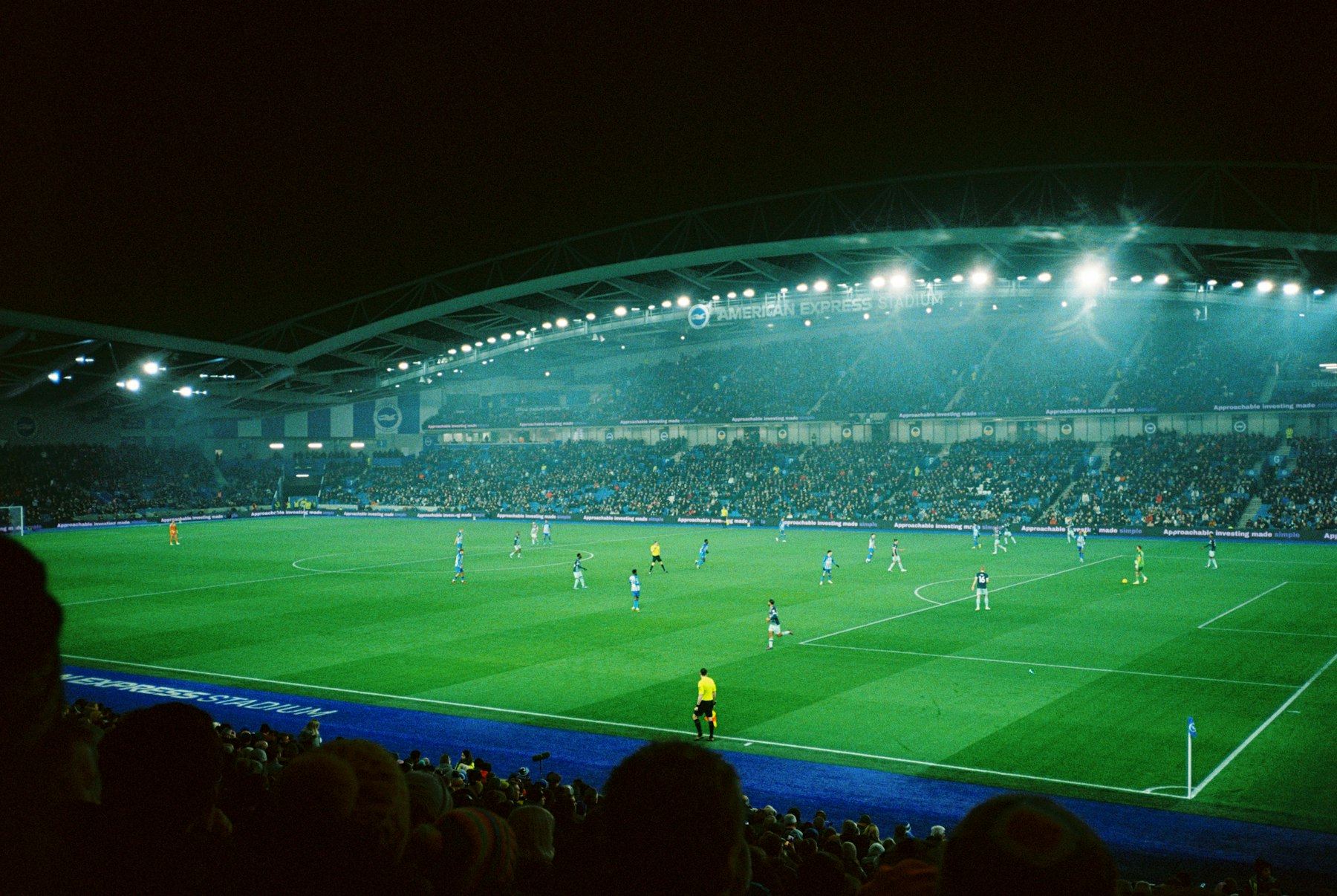 Floodlit football stadium during an evening match