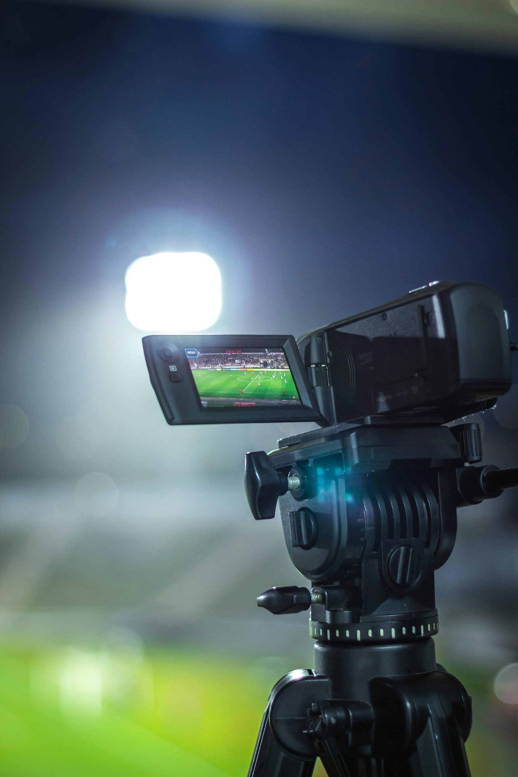 Pitchside video camera filming a football match at night