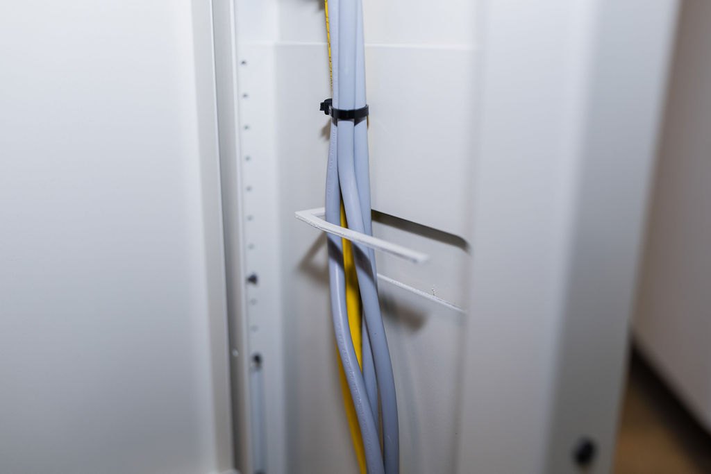 Kabel im SMESK-Tisch sauber gebündelt und mit Halterungen befestigt für ein geordnetes Kabelmanagement