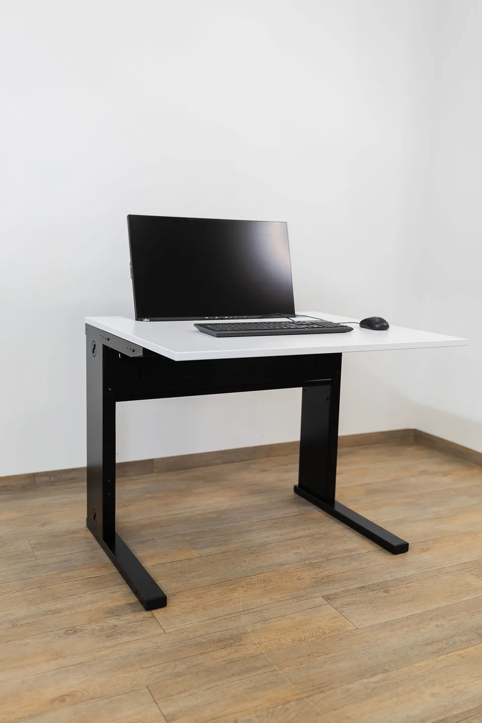 SMESK Semi Arbeitsplatz: der Monitor steht halb eingelassen in der weißen Tischplatte, davor liegen Tastatur und Maus
