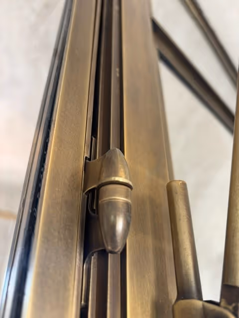 Close-up view of a brass sliding bolt lock mechanism on a door.