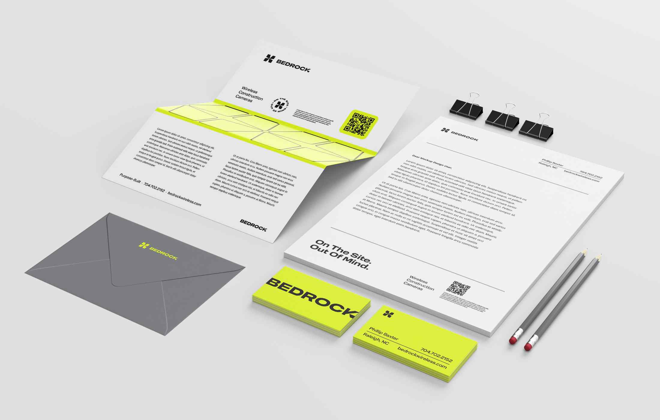 Various Big Mood Spa skincare products arranged next to two vases with pink and white flowers on a light beige background.