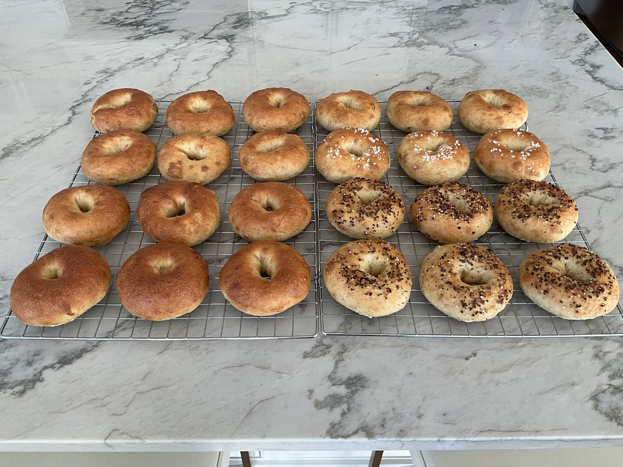 Different kinds of Sourdough Bagels on baking trays.