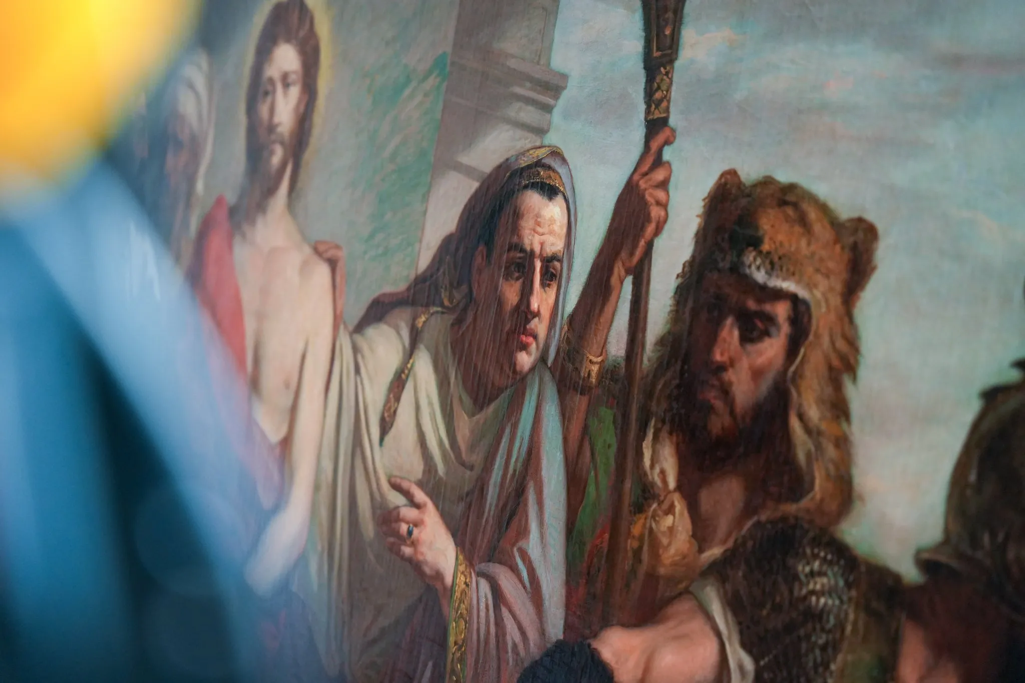 Peinture murale représentant une scène biblique avec un homme à la tête couverte d'un manteau pointant du doigt et un guerrier portant un casque en peau d'ours.